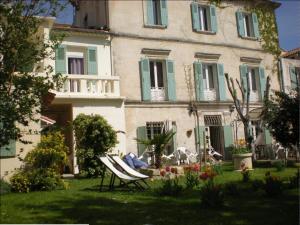 een huis met een tuin met een stoel ervoor bij Au Saint Roch - Hôtel et Jardin in Avignon