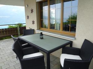 una mesa y sillas en un patio con ventana en B&B Haussener en Krattigen