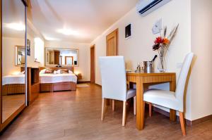 Zimmer mit einem Tisch und Stühlen sowie einem Schlafzimmer in der Unterkunft Guest House Golden Goose in Rovinj