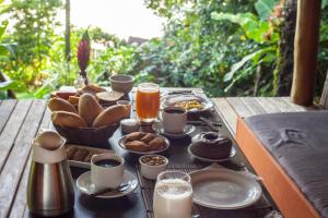 ボイペバ島にあるDendê Loftのテーブルの上に朝食用の食品とドリンクのトレイ