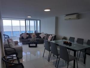 a living room with a couch and a table and chairs at Espectaculares Vistas, Edificio Nautilus, Barrio El Laguito. in Cartagena de Indias