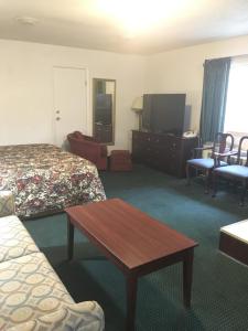 Habitación de hotel con 2 camas y mesa en Rapids Inn & Suites, en Wisconsin Rapids