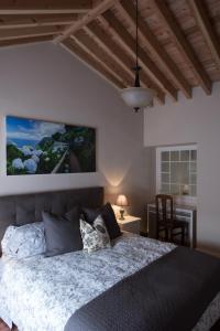 a bedroom with a bed and a table with a chair at Surf Beach_Santa Barbara Secret Gardens in Ribeira Grande