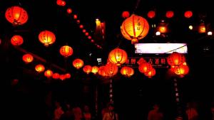 um grupo de lanternas vermelhas numa rua à noite em Corner Inn九份住宿I 小角落民宿I 機車租借I日夜間導覽 em Jiufen