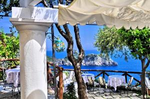 vista para o oceano a partir de um restaurante com mesas e cadeiras em Albergo La Conca Azzurra em Conca dei Marini