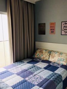 a bedroom with a bed with a quilt on it at Boulevard Center in Guarujá