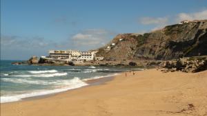 una playa con gente caminando por la arena en Laurel Beach House, en Lourinhã