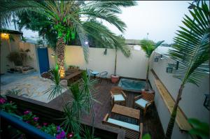 a balcony with a patio with a pool and palm trees at Eshel Mansion - Boutique Suites in Beer Sheva