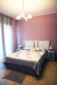 a bedroom with a large bed with purple walls at Casamia B&B in Castelletto sopra Ticino