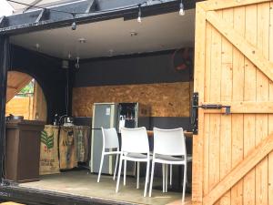 a group of white chairs sitting on a patio at Mayhow Donghe in Donghe