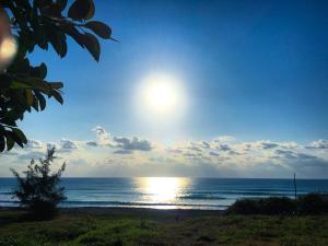 a view of the ocean with the sun in the sky at Mayhow Donghe in Donghe