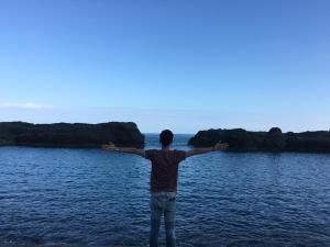 a man standing in the water with his arms out at Mayhow Donghe in Donghe