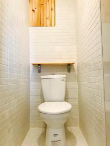 a bathroom with a white toilet in a room at Mayhow Donghe in Donghe