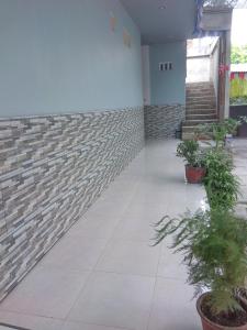 a hallway with plants and a brick wall at Penginapan Artha in Praya