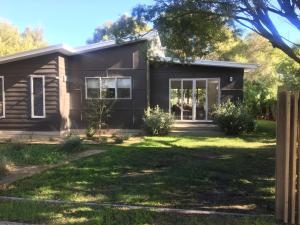 a house with a green lawn in front of it at Tamara Beach House in Inverloch