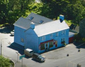 un edificio blu con un camion parcheggiato di fronte di Herlihy's, Half-Way-House a Farranfore