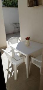 阿韋特拉納的住宿－Le 5 Volte，白色的桌子和椅子,上面有花瓶