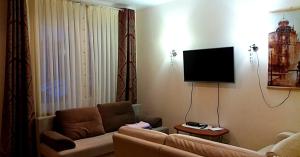 a living room with a couch and a flat screen tv at Квартира студия на Банном in Yakty-Kul