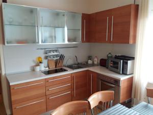 a small kitchen with wooden cabinets and a microwave at Квартира студия на Банном in Yakty-Kul