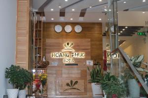 Hoang Phuc Hotel في Thu Dau Mot: واجهة متجر وساعات على جدار خشبي