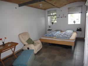 ein Schlafzimmer mit einem Bett und einem Stuhl darin in der Unterkunft Nordkap Farm Holiday & Hostel in Bindslev