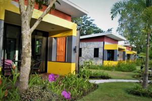 a house with a colorful front yard with flowers at Nubdao Resort&Restaurant in Nong Prue
