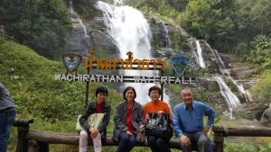 a group of people sitting in front of a waterfall at Home Baan Chiang Mai in Chiang Mai