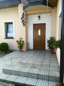 a front door of a house with potted plants at Wczasy U Piotra in Grabno