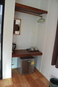 Habitación pequeña con escritorio y nevera pequeña. en Nubdao Resort&Restaurant en Nong Prue