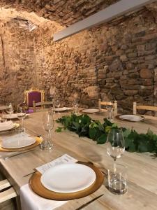 una mesa de madera con platos y copas de vino. en Hotel Secrets Priorat en Falset