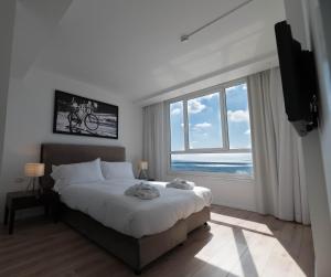 um quarto com uma cama grande e uma janela grande em Sea view apartment suite em Tel Aviv