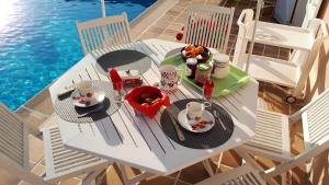 a table with food and drinks on it next to a pool at La petite maison - L'Ouche Charlot in Maux