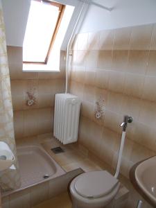 een badkamer met een toilet, een bad en een wastafel bij Révész Vendégház in Harkány