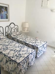 two beds in a room with blue and white sheets at Cottage in Panarea in Panarea