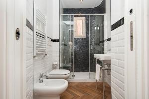 biała łazienka z toaletą i prysznicem w obiekcie Luxury & Charme Colosseo w Rzymie +17 zdjęć