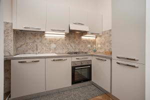 kuchnia z białymi szafkami i piekarnikiem w obiekcie Luxury & Charme Colosseo w Rzymie