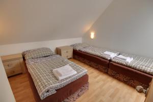 dwa łóżka pojedyncze w pokoju z drewnianą podłogą w obiekcie Guest House Pod Hájkem w mieście Horní Branná +37 zdjęć