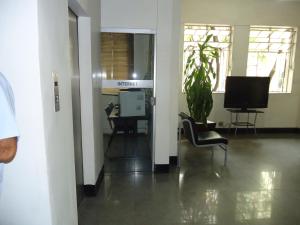 an office with a television and a chair in a hallway at Hotel Turista in Belo Horizonte