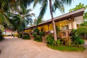 a building with palm trees in front of it at Anika Island Resort in Bantayan Island