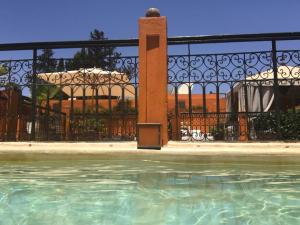 a pool of water in front of a fence at Riad Hermès in Marrakesh