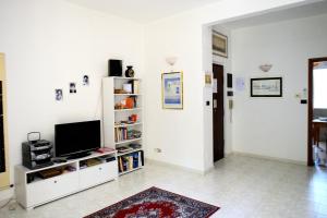 salon z telewizorem na białej półce w obiekcie Donna Lavinia a Cinecittà w Rzymie