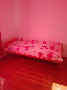 a bed in a room with a pink wall at HALEX5 in Svidova