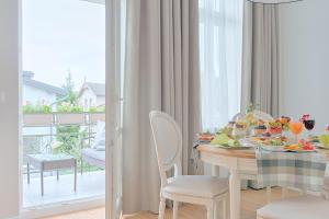 a dining room with a table and chairs and a balcony at Apartamenty Molo Residence in Sopot