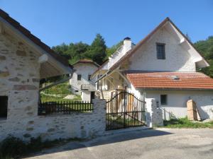 Uma casa branca com um portão à frente. em L'Hermitage em Yenne
