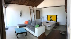 - un salon avec un canapé et un lit dans l'établissement KiteParadise-Madagascar, à Diego Suarez