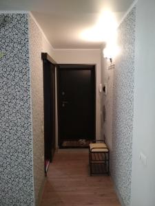 korytarz z czarnymi drzwiami i stołem w obiekcie Apartment on Shevchenko w mieście Almietjewsk
