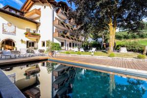 ein Hotel mit einem Pool vor einem Gebäude in der Unterkunft Solaia Hotel & Guesthouse in Kastelruth