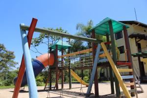 un parque infantil con un tobogán y un tobogán en Hotel do Santuário, en Nova Trento
