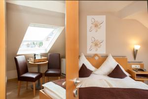 ein Hotelzimmer mit einem Bett und einem Fenster in der Unterkunft Moselhaus Weiskopf in Bernkastel-Kues