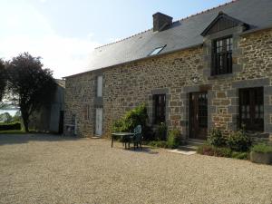 un edificio de piedra con un banco delante en gite des ferrieres, en La Ville-ès-Nonais